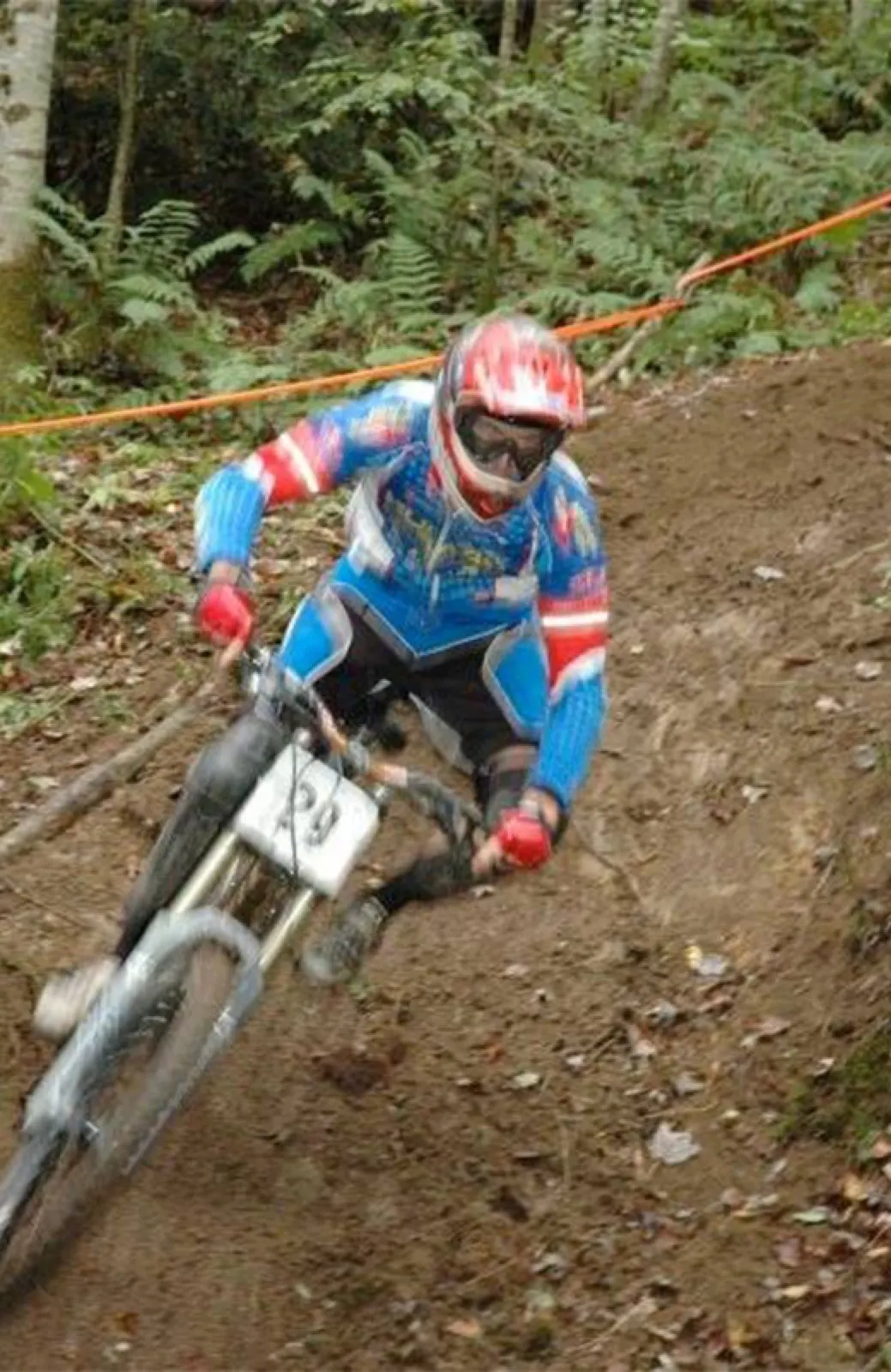 Sam Silvey racing a downhill mountain bike through a dirt corner